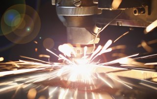 Image of a CNC machine in production with sparks flying.
