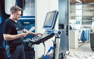 A CNC machinist entering in data